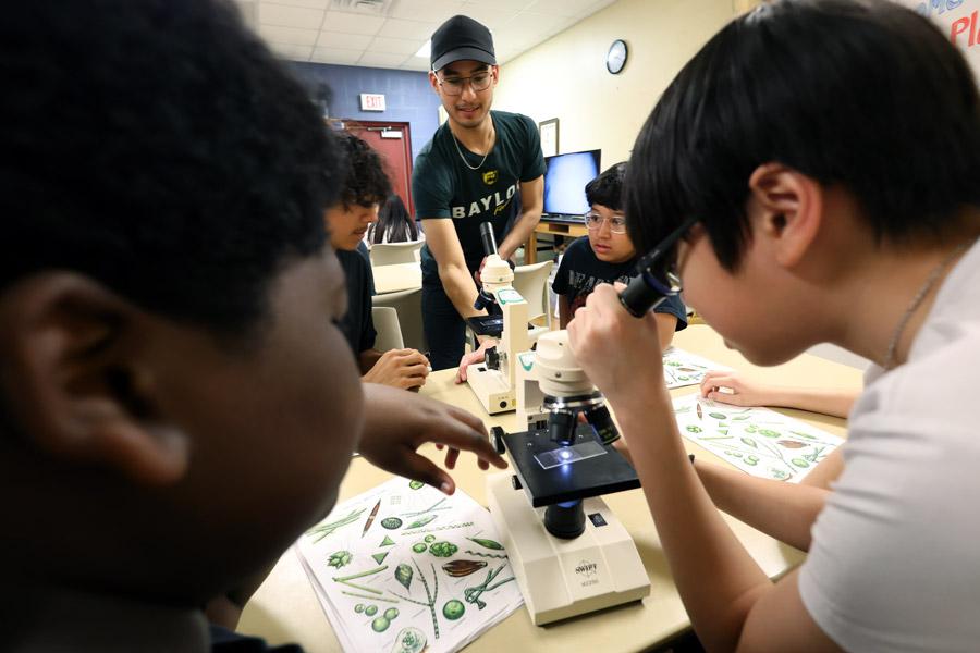 Baylor student helps local students learn how to use a microscope