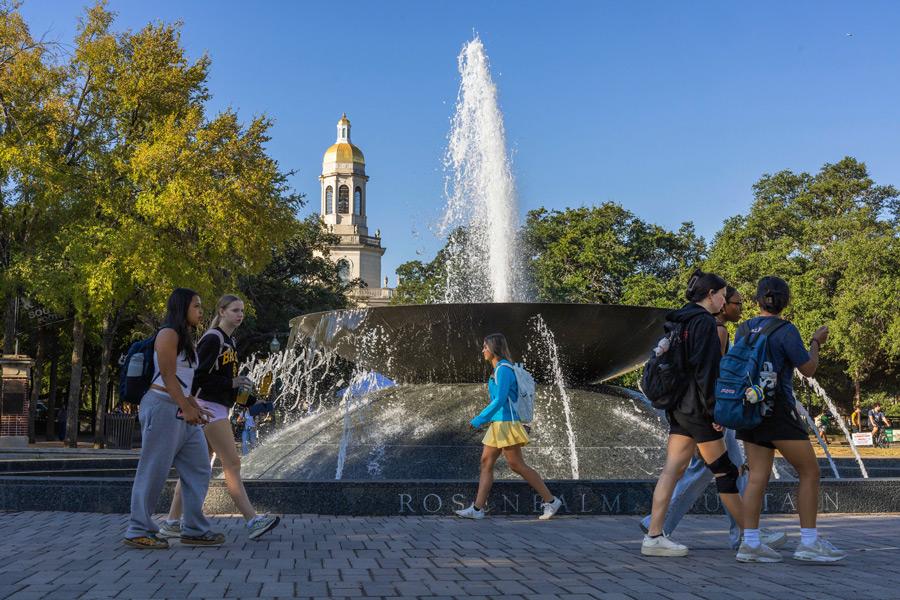 Baylor students walk along 5th Street near the Rosenbalm Fountain